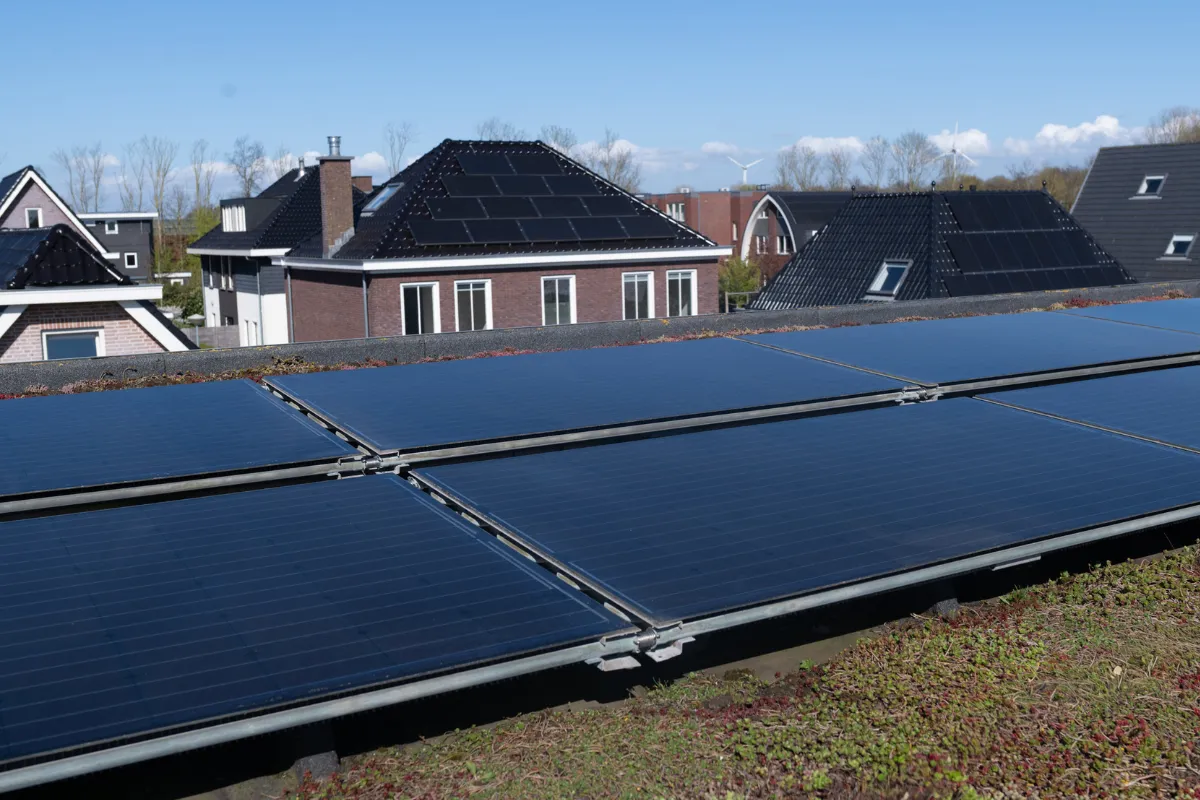 Duurzaam huis gesymboliseerd door een huisvorm bedekt met groen gras, verwijzend naar energiezuinige woningen.